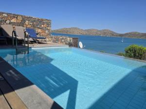 a swimming pool with a view of the water at Andromeda Sea View Villa in Epáno Eloúnda