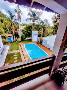 a view of a swimming pool from the balcony of a house at Morada Palmeira Real Peruibe - SP in Peruíbe
