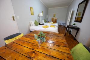 a room with a wooden table and a bed at Beyond Cui Bono - Travel Addo Group in Sunland +48 photos