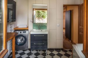 a bathroom with a sink and a washing machine at The Dragon Barn - Grenier in Ascou +26 photos