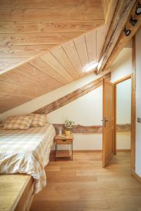 a bedroom with a bed and a wooden ceiling at The Dragon Barn - Grenier in Ascou