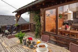 a wooden deck with a table with food on it at The Dragon Barn - Grenier in Ascou