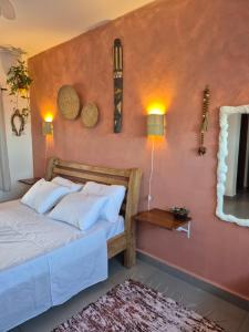 a bedroom with a bed and a pink wall at Morada Palmeira Real Peruibe - SP in Peruíbe +42 photos