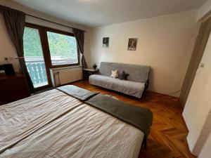 a bedroom with a couch and a cat laying on a bed at Hiša Jezersko in Zgornje Jezersko