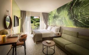 a hotel room with a bed and a couch at Remisens Hotel LUCIJA in Portorož