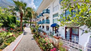 a walkway in front of a building with flowers at del Mare Hotel Ölüdeniz in Oludeniz