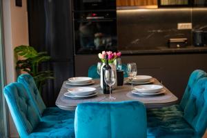 a table with blue chairs and a table with flowers on it at Alba Azzura in Zaton +27 photos
