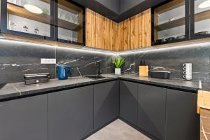 a kitchen with black counters and wooden cabinets at Alba Azzura in Zaton