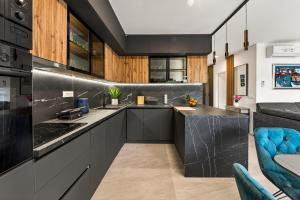 a kitchen with black cabinets and blue chairs at Alba Azzura in Zaton