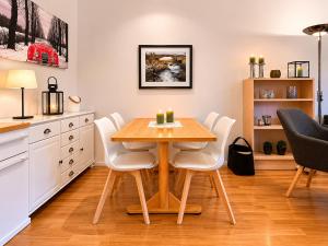 a kitchen with a wooden table and white chairs at Central Apartment in Geilo in Geilo +6 photos