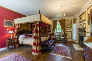 a bedroom with a canopy bed and red walls at Lickleyhead Castle in Insch