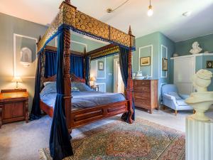 a bedroom with a canopy bed and a chair at Lickleyhead Castle in Insch