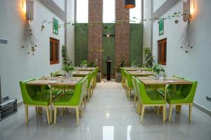 a dining room with wooden tables and green chairs at Blue Bird Hotels in Negombo +47 photos