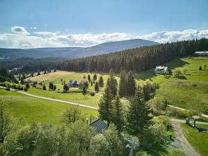 an aerial view of a field with a house and trees at Glamping KOLBENKA in Horní Malá Úpa