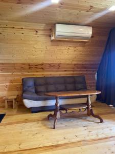 a living room with a couch and a table at Sunset Cottage Busheti in Busheti