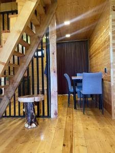 a dining room with a table and blue chairs at Sunset Cottage Busheti in Busheti +1 photo