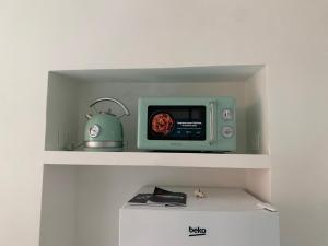 a microwave oven sitting on top of a shelf at Suite Arcobaleno in Deiva Marina