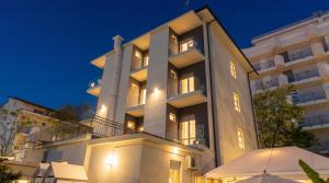 a large white building with umbrellas in front of it at B&B Hotel Villa Nora in Bellaria-Igea Marina