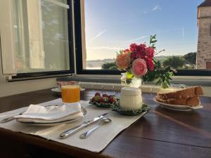 a table with a breakfast of food and a window at Logis de la Jordronnière, Chambre d hôtes in Sigournais