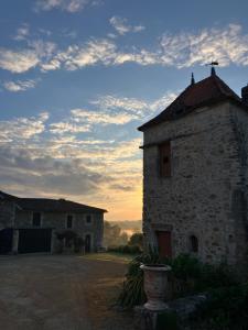 an old stone building with a sunset in the background at Logis de la Jordronnière, Chambre d hôtes in Sigournais