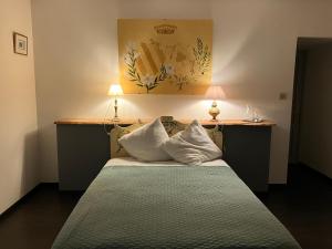 a bedroom with a bed with two pillows on it at Logis de la Jordronnière, Chambre d hôtes in Sigournais