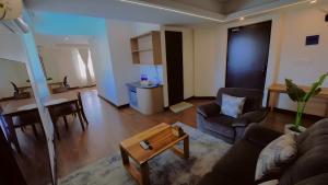 a living room with a couch and a table at Aijal Club in Āīzawl +4 photos