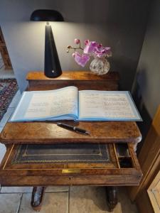 an open book on a wooden table with a lamp at Drumee Lodge boutique B and B, Newcastle, County Down in Newcastle