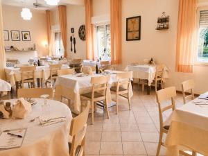 a restaurant with tables and chairs with white tablecloths at Hotel Villa Gioiosa - Beach & Bistrot in Rimini