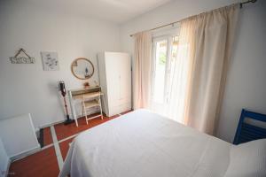 a bedroom with a white bed and a window at Casa Edison in Conil de la Frontera