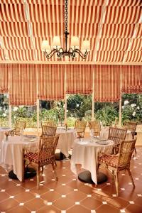 a dining room with tables and chairs and a chandelier at La Bastide de Saint Tropez in Saint-Tropez