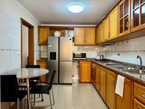 a kitchen with a table and a stainless steel refrigerator at Cantinho de Santa Teresa in Canhas