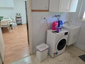 a kitchen with a washing machine and a sink at Girrawheen3 - Room in a Shared House in Perth