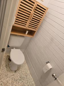 a bathroom with a toilet with a shelf above it at Girrawheen3 - Room in a Shared House in Perth