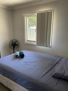 a bedroom with a large bed with a window at Girrawheen3 - Room in a Shared House in Perth