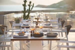 a table with glasses of wine and plates of food at 18 Grapes Hotel in Agios Prokopios