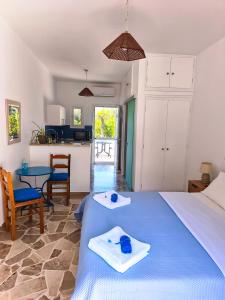 a bedroom with a bed and a table and a kitchen at Bungalows Ingrid in Tolo