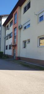 a large white building with windows on a street at Apartman Katić 2 in Odžak
