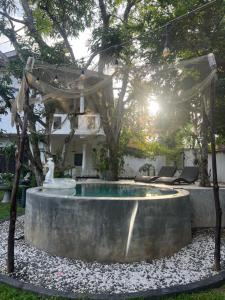 a small pool in a yard with a tree at AmoreBay in Mirissa