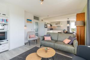 a living room with a couch and a table at Appartementencomplex Juliana 132 in De Koog +6 photos