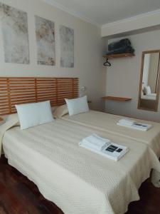 a bedroom with a bed with two pillows and a mirror at Pensión 813 in Palas de Rei