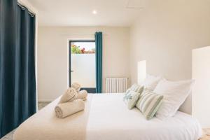 a bedroom with a large white bed with blue curtains at Petit Albert, confortable, proche de La Rochelle in Aytré