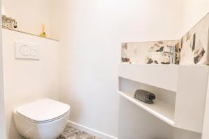 a white bathroom with a toilet and a shelf at Petit Albert, confortable, proche de La Rochelle in Aytré +32 photos