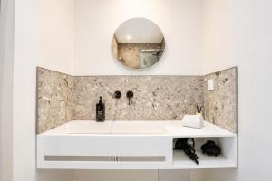a bathroom with a white sink and a mirror at Petit Albert, confortable, proche de La Rochelle in Aytré