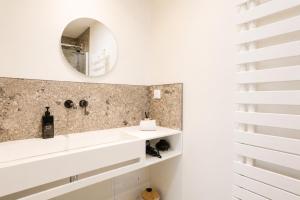 a bathroom with a sink and a mirror at Petit Albert, confortable, proche de La Rochelle in Aytré