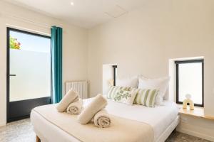 a bedroom with a large bed with two windows at Petit Albert, confortable, proche de La Rochelle in Aytré
