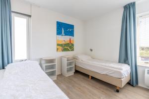 a bedroom with two beds and a window at Appartementencomplex Juliana 132 in De Koog