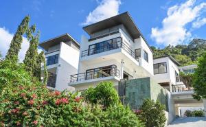 a white house with balconies and trees at Skyline Seaview Villa-5 Bedroom, 4 Bathrooms with Private Seaview Pool in Ban Thong Phlu