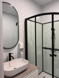 a bathroom with a sink and a glass shower at Vatra Dumeniului in Vorniceni