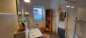 a small bathroom with a sink and a window at Haus Admaris am Wangermeer in Wangerland