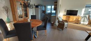 a kitchen and dining room with a wooden table and chairs at Haus Admaris am Wangermeer in Wangerland +8 photos